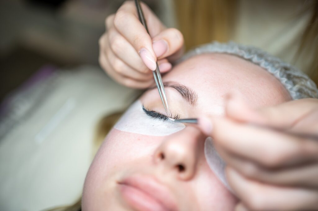 Eyelash extension procedure in beauty salon. Lashes close up. Concept spa lash.